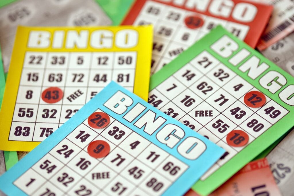 Many colorful bingo boards or playing cards for winning chips. Classic american or canadian five to five bingo cards on bright background