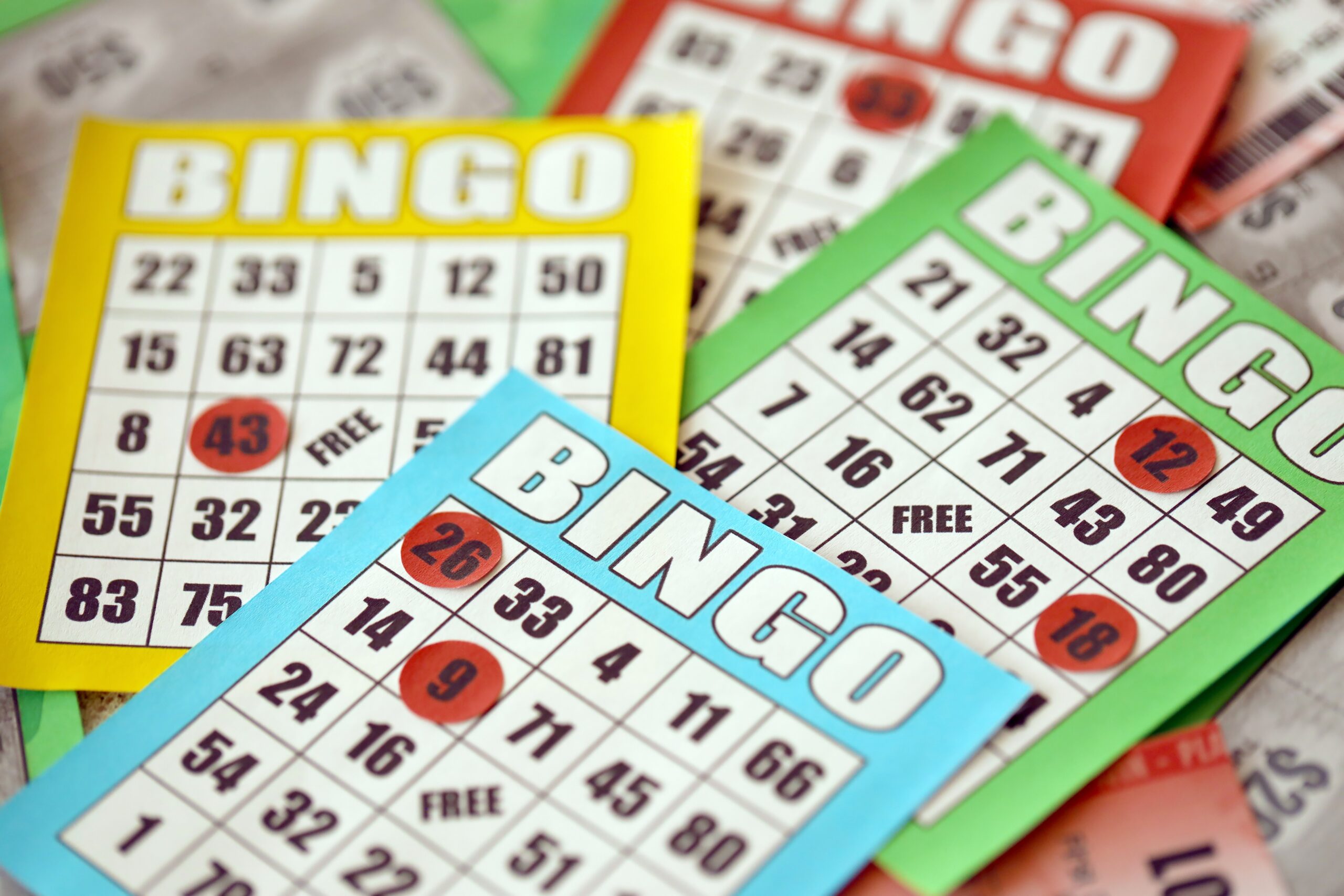 Many colorful bingo boards or playing cards for winning chips. Classic american or canadian five to five bingo cards on bright background