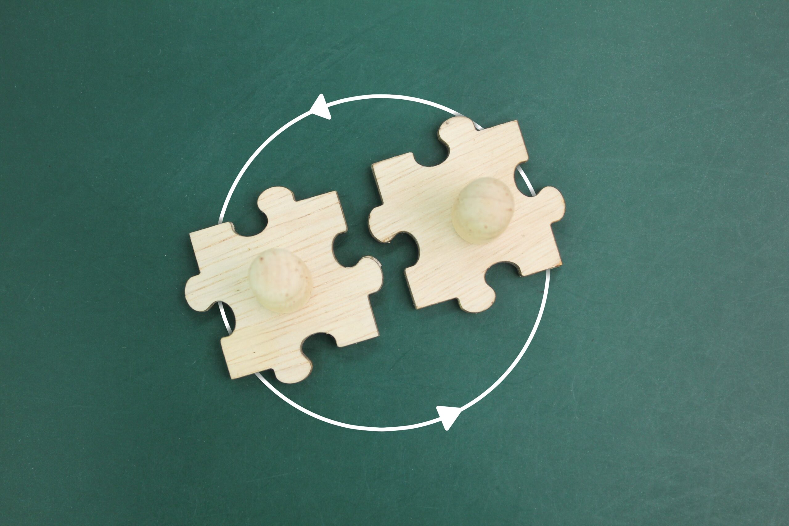 top view of a wooden puzzle with two pegdolls joined together. two wooden people join together. Business mergers and acquisitions, partnership concept.