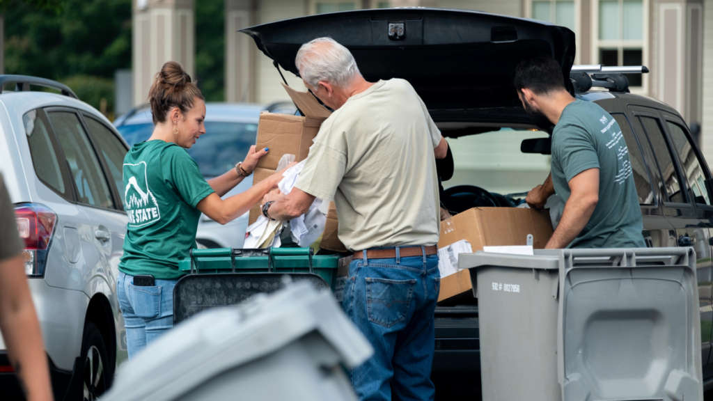 people dropping paper work in a bin for Shred-It Day
