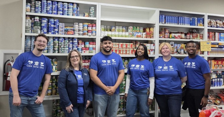 Texas Trust Credit Union employees pose for photo while doing work at a local food bank