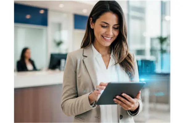 A modern, friendly credit union member or employee using a tablet or smartphone in a bright, clean financial setting.