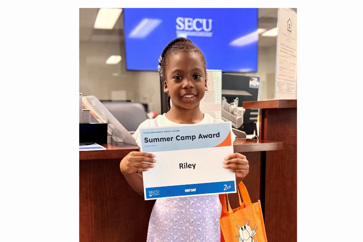 Riley Hines accepts her $500 Summer Camp Award from the Greenville-First Street Branch.